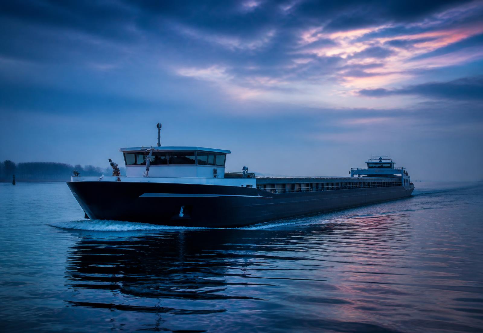 Binnenvaartschip op kalm water in de vroege ochtend